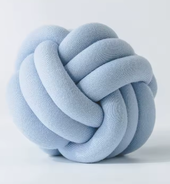 Chunky gevlochten knoopkussen in lichtblauwe kleur – zacht en rustgevend, perfect voor een frisse uitstraling.
