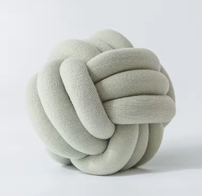 Chunky gevlochten knoopkussen in groene kleur – natuurlijk en verfrissend, ideaal voor een organische look.