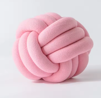 Chunky gevlochten knoopkussen in zachte roze kleur – een charmante toevoeging aan je slaapkamer of woonkamer.