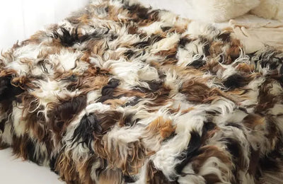 Close-up van een natuurlijke dierenhuid met gevlekt patroon in beige en bruine tinten, zichtbaar haarstructuur en organische textuur