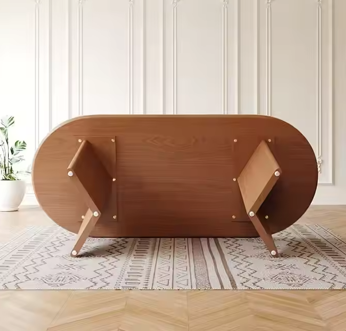 Onderaanzicht van een ovale houten eettafel met stevige houten poten op vloerkleed.