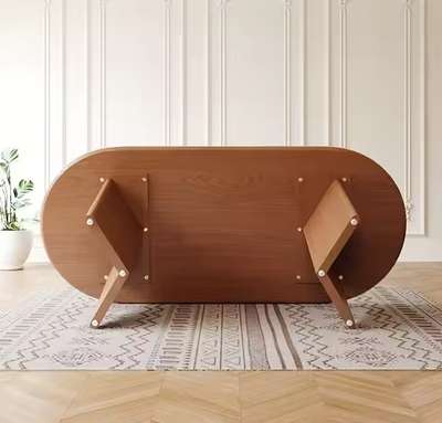 Onderaanzicht van een ovale houten eettafel met stevige houten poten op vloerkleed.