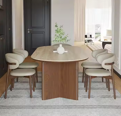 Moderne eettafel van hout met afgeronde hoeken en zes designstoelen in een stijlvol interieur.