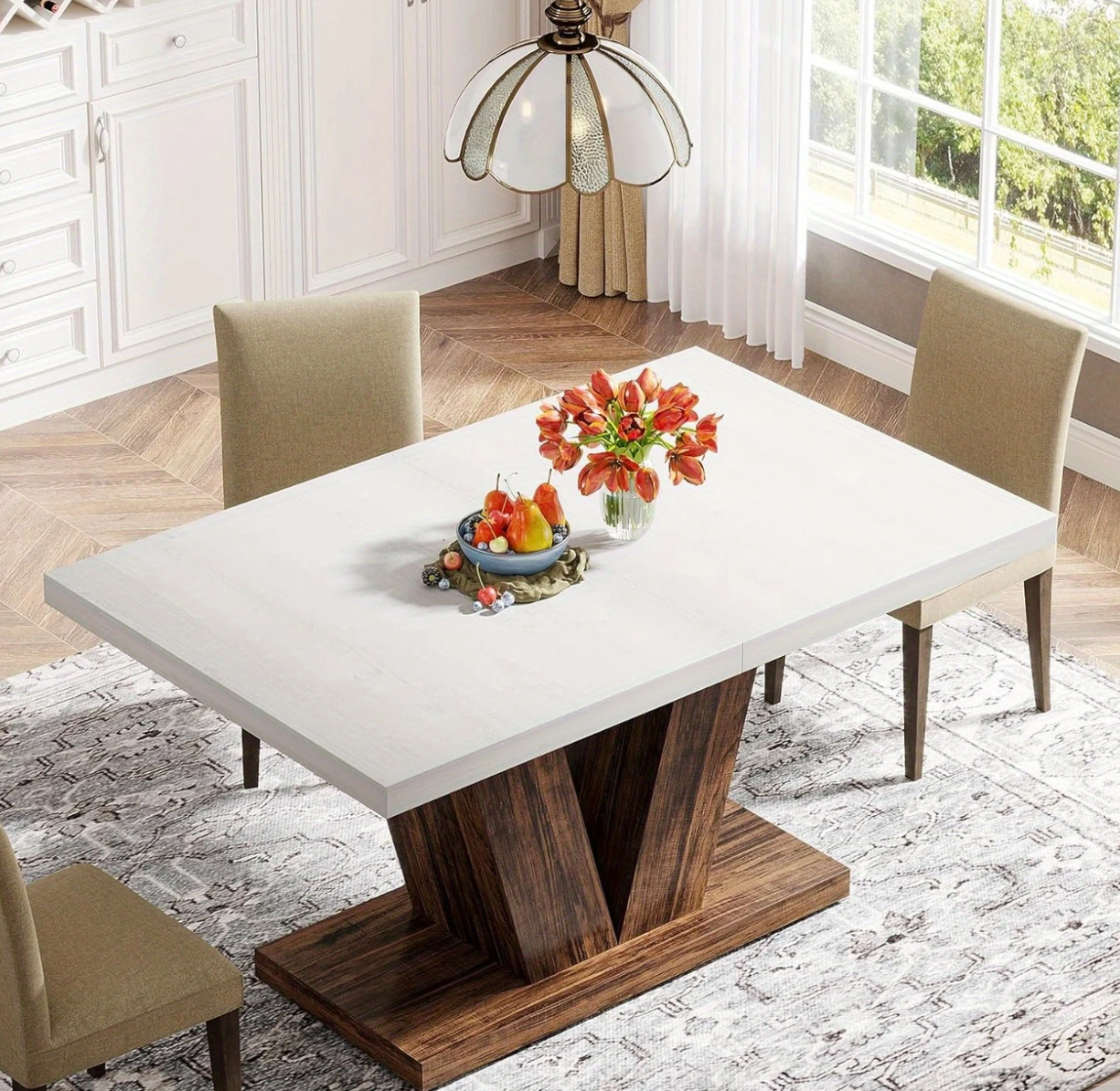 Zijaanzicht van de tafel in een interieur met twee beige stoelen en decoratie op het witte tafelblad. Tafel in zonnige eetkamer met vier stoelen en herfstbloemstuk op het blad.
