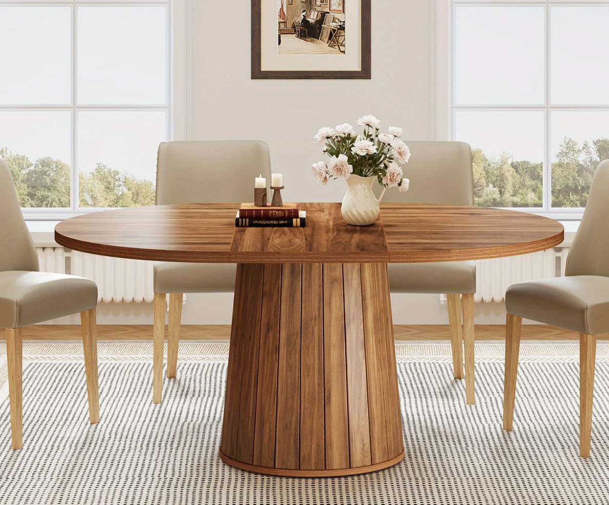 Ovale houten eettafel van 140 cm met cilindrische poot, omringd door vier beige stoelen in een lichte eetkamer.