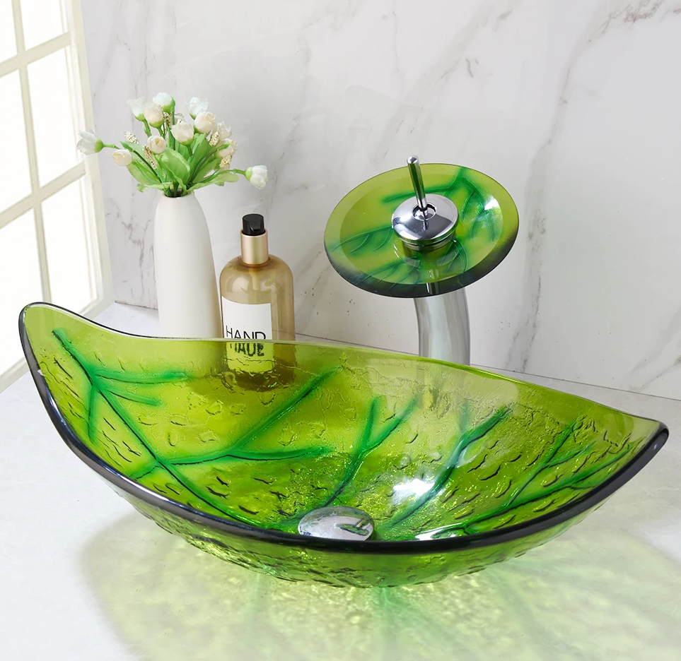Groene glazen waskom met organisch design en bijpassende waterval kraan – modern badkamerontwerp.