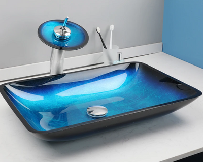 Rechthoekige blauwe glazen waskom met watervalkraan op wit badkamerblad – modern en stijlvol design.