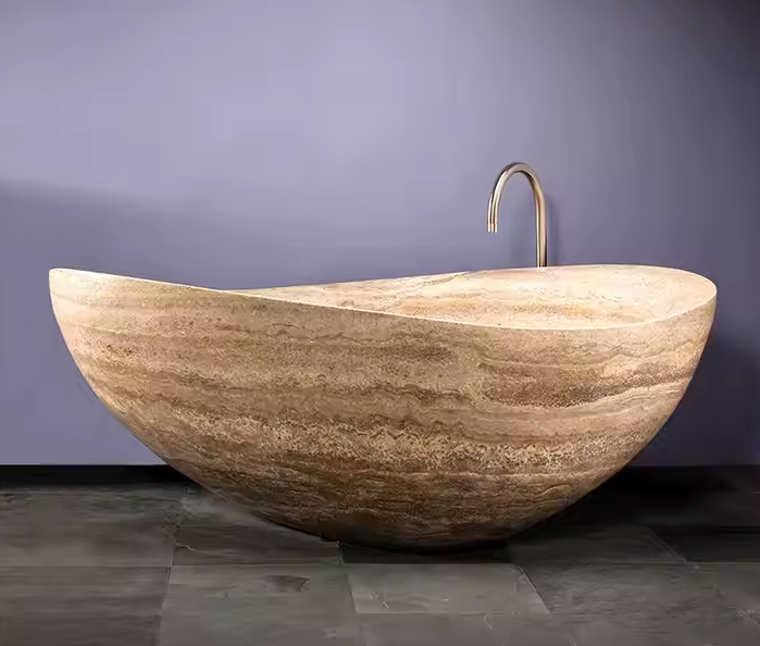 Natuurstenen badkuip in warm beige travertin – rustgevend design voor spa-achtige badkamers.