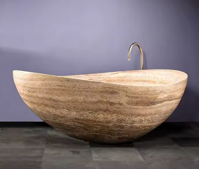 Natuurstenen badkuip in warm beige travertin – rustgevend design voor spa-achtige badkamers.