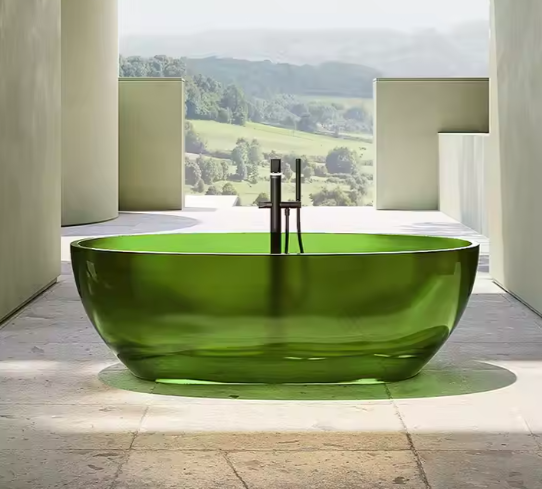 Vrijstaande ovale badkuip in transparant groen resin, geplaatst op grijze steentegels in open buitenruimte; voorzien van minimalistische chromen kraan en omringd door architectonische zuilen, met uitzicht op heuvelachtig natuurlandschap vol groen; een stijlvol samenspel van wellness en natuur in moderne setting
