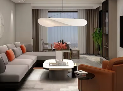Stijlvolle woonkamer met sculpturale Italiaanse hanglamp van handgeweven stof – moderne verlichting boven zithoek met oranje accenten, botanische decoratie en warme ambiance.
