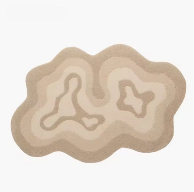 Fluffy vloerkleed in organische vorm met concentrisch patroon in beige en crème tinten; design doet denken aan topografische lijnen met centrale vormen die lijken op abstracte eilandjes; afgebeeld in neutrale setting zonder meubilair, een hoogpolig en zacht vloerkleed dat rust en stijl toevoegt aan een modern interieur