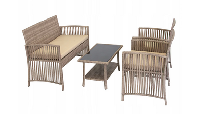 Vierdelige loungeset voor buiten bestaande uit een tweezitsbank, twee fauteuils en een rechthoekige salontafel met glazen blad en onderliggend rotan plankje; uitgevoerd in donker gevlochten kunststof (PE rotan) met beige zit- en rugkussens; de meubels zijn geplaatst op een terras met grijze vloer en vormen een stijlvolle en comfortabele zithoek voor tuin, balkon of patio
