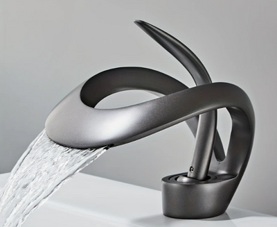 Design wastafelkraan in sculpturale lusvorm met glanzende chroomafwerking, gemonteerd op witte wastafel met stromend water; kraan combineert een minimalistische stijl met artistieke elegantie en functionele werking, een opvallende blikvanger in moderne badkamer met strakke lijnen en neutrale tinten