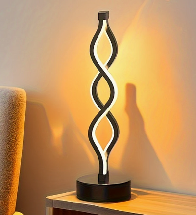 Moderne spiraalvormige LED tafellamp met warm licht – decoratieve verlichting op houten tafel naast sofa, perfect voor sfeervolle woonkamers en designinterieurs.