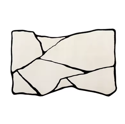 Abstract vloerkleed in rechthoekige vorm met lichtbeige achtergrond en patroon van grillige zwarte lijnen, die het oppervlak opdelen in onregelmatige fragmenten als gebroken scherven of topografische zones; afgebeeld zonder meubilair op neutrale ondergrond, een grafisch en modern tapijt dat visuele diepte en karakter toevoegt aan hedendaags interieur