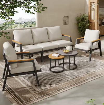 Industriële buiten loungeset met gegalvaniseerd stalen frame en lichtgrijze, weerbestendige kussens – driezitsbank, twee fauteuils en dubbele salontafels (marmeren glas & kunsthouten blad) op modern terras met tuin- en balkonzicht