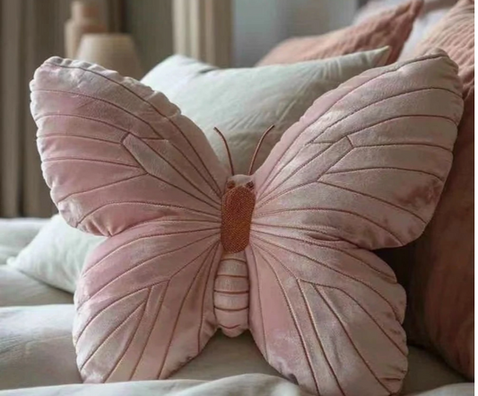 Roze velvet vlinderkussen op een bed met zachte neutrale tinten.