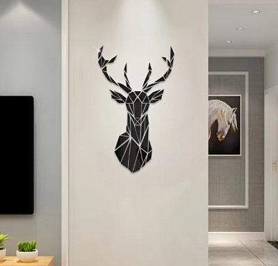 Geometrisch hertenhoofd wanddecoratie in zwarte acryl, bevestigd op een witte muur in een modern interieur; rechts hangt een ingelijste afbeelding van een witte paardenkop, links staat een kleine tafel met plant, en op de voorgrond is een zwart rechthoekig object zichtbaar, mogelijk een televisie; het abstracte diermotief voegt een artistiek accent toe aan de strakke en neutrale ruimte, perfect voor Art Deco of minimalistische woonstijlen